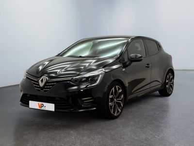 Une voiture noire est garée dans une pièce aux murs blancs.