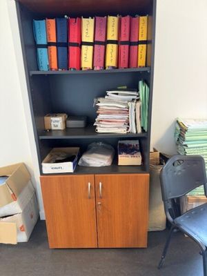 une bibliothèque contenant de nombreux dossiers, avec une chaise placée devant