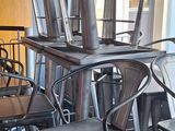 des tables et des chaises dans un restaurant, avec une grande baie vitrée en arrière-plan