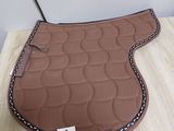 the saddle pad is made of leather and has a stitching pattern on it