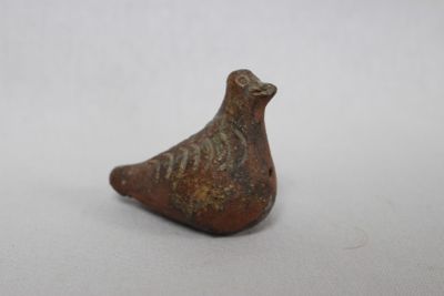 a close up of a bird figurine on a white surface