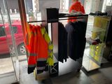 a woman standing in front of a store with a rack of clothing