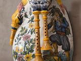 un vase orné d'un oiseau, accroché au mur