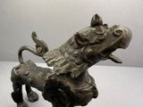 figurine en bronze représentant un chien avec un oiseau sur la tête