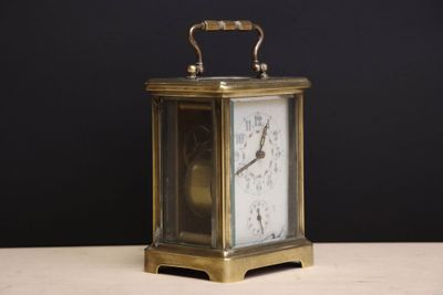 a small clock sitting on a table with a black background
