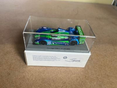 a small toy car in a clear box on the floor