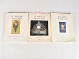 three books on a white table with a pink ribbon on top of them