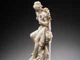 a white statue of a woman sitting on top of a marble base