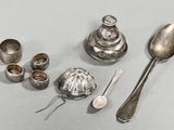 cuillères en argent, tasses et cuillères à soupe posées sur une table