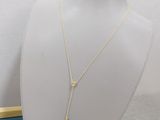 a white mannequin with a gold necklace on it
