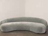 an image of a curved couch sitting on top of a wooden floor
