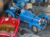many toy cars that are on display in a glass case