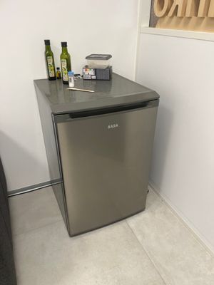 un petit réfrigérateur dans un coin d'une petite pièce