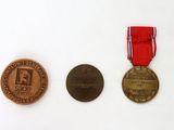 three medals and a medal on a white surface