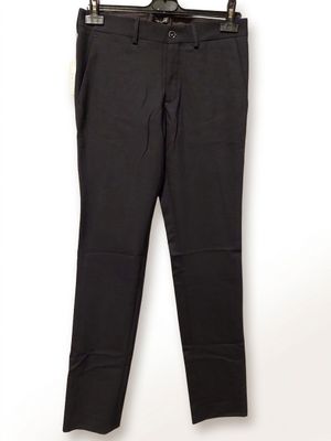 un pantalon noir suspendu à un cintre devant un mur blanc