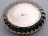 an image of a silver plate with a flower design on it