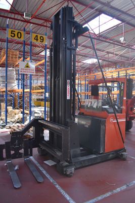 a forklift in a warehouse with pallets in the foreground