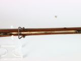 an old rifle with a wooden barrel and metal handle on a white surface