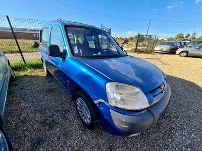 La camionnette bleue est garée sur un parking, à côté d'autres voitures.