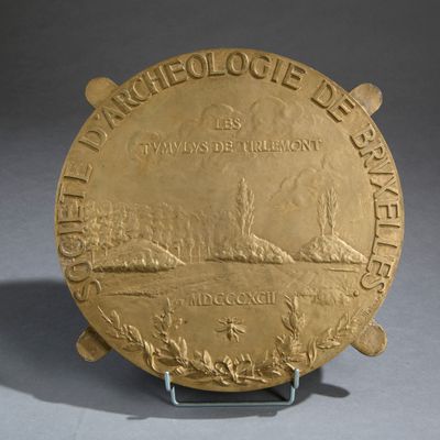 an image of a gold plate with a picture of a ship on it
