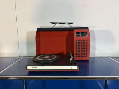 a red and black radio sitting on top of a blue table