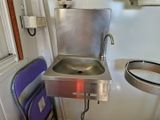 un lavabo et une chaise dans une petite pièce