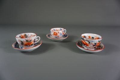 trois tasses et soucoupes ornées de motifs orange et bleus