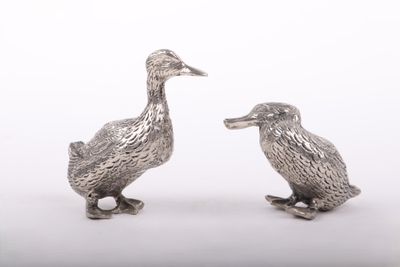 pair of silver duck figurines on a white background