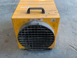 a yellow heater sitting on the ground next to a sign