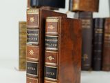 several old books are stacked on top of each other on a table