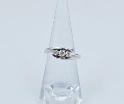 une image d'une bague en diamant posée sur un verre transparent