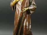 statue en bronze représentant une femme tenant ses mains dans sa main droite