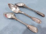 three silver spoons sitting on top of a table next to each other