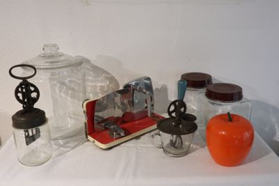 a white table topped with glass jars and a red apple