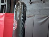 a man that is standing in a gym with a punching bag