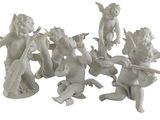a group of figurines of angels sitting on a white surface