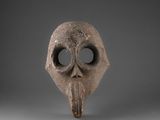 un gros plan d'un masque au long nez sur fond gris