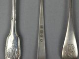 three spoons and a fork on a table