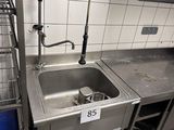 un évier au milieu d'une cuisine, à côté d'un bac de tri bleu