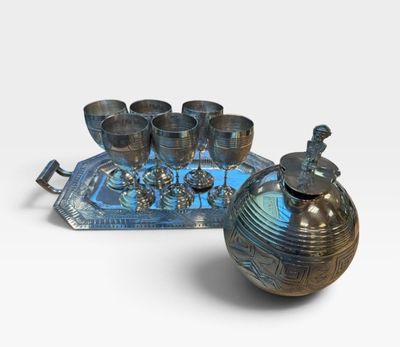 a blue tray with a silver tea set and a tray with silver cups