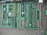 a green tool box with tools in it on the ground