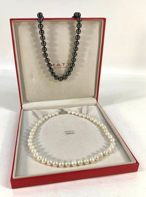 un collier de perles blanches dans un coffret rouge sur fond blanc