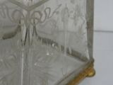 a glass box with a gold lid on a white surface