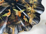 a decorative plate with birds on it sitting on a table