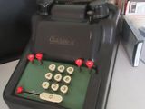 une vieille machine à écrire posée sur un bureau, à côté d'un ordinateur portable