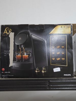 une boîte sur laquelle est posée une machine à café, posée sur une étagère