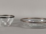 deux petits bols en verre aux bords argentés posés sur une surface blanche