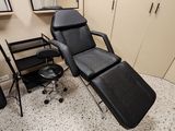 a black chair in a room with a mirror on the wall