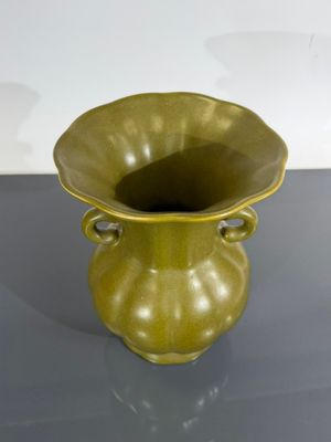 un vase vert posé sur une table
