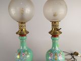 une paire de lampes en verre vert ornées de finitions dorées et de motifs floraux